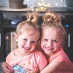 girl in pink crew neck t-shirt smiling beside girl in pink t-shirt