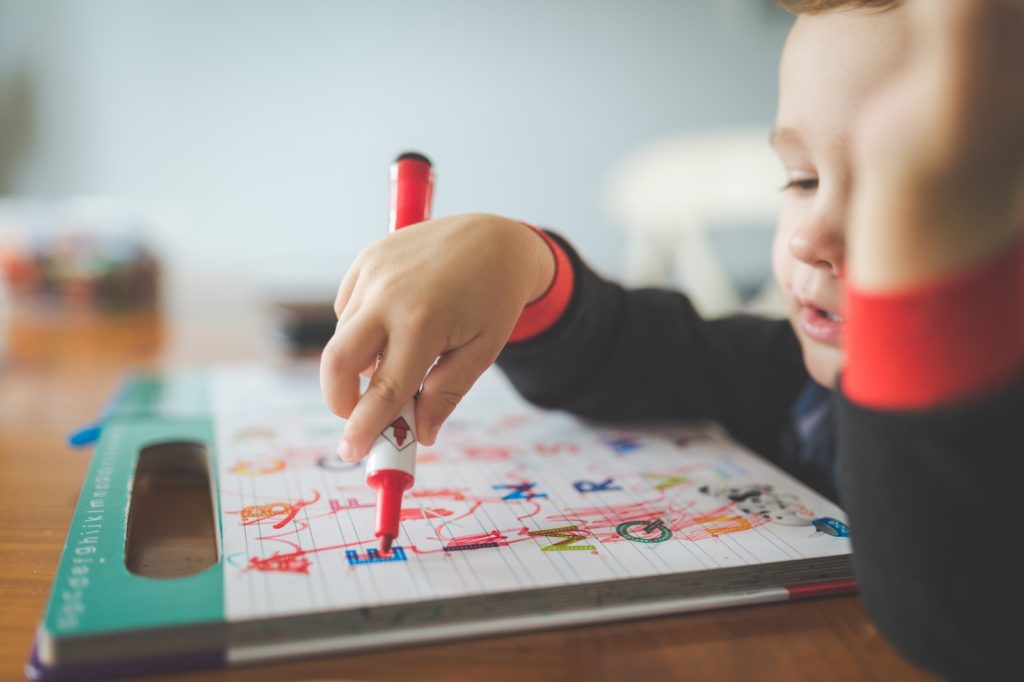 a young child is drawing on a piece of paper