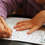 a child is drawing on a piece of paper