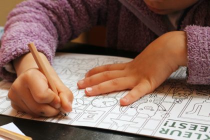 a child is drawing on a piece of paper