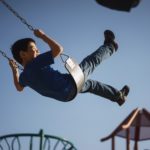 boy sitting on swing chair